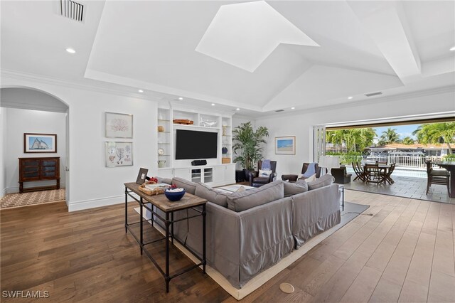 living room featuring crown molding, wood-type flooring, and built in features