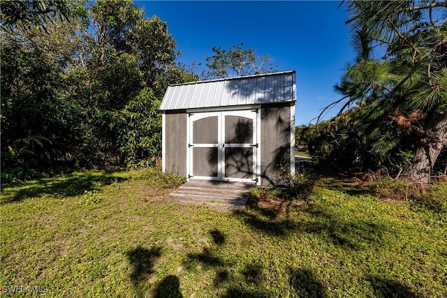 view of outbuilding featuring a lawn