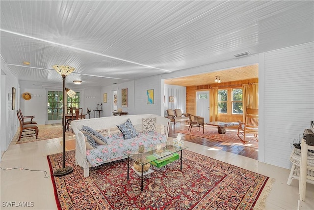 living room featuring plenty of natural light and wood walls