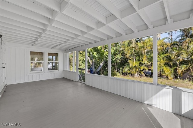 unfurnished sunroom featuring beamed ceiling