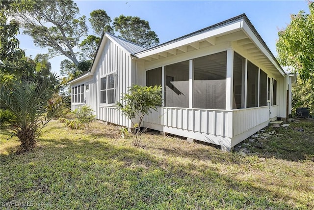 view of property exterior featuring a yard and a sunroom