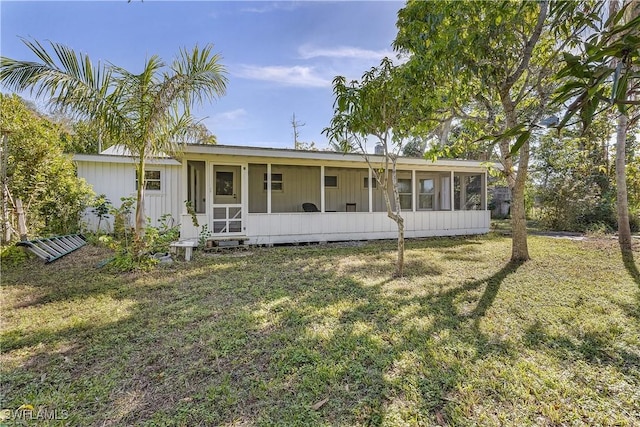 view of front facade with a front yard and a sunroom