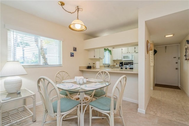 dining space featuring light tile patterned floors and sink