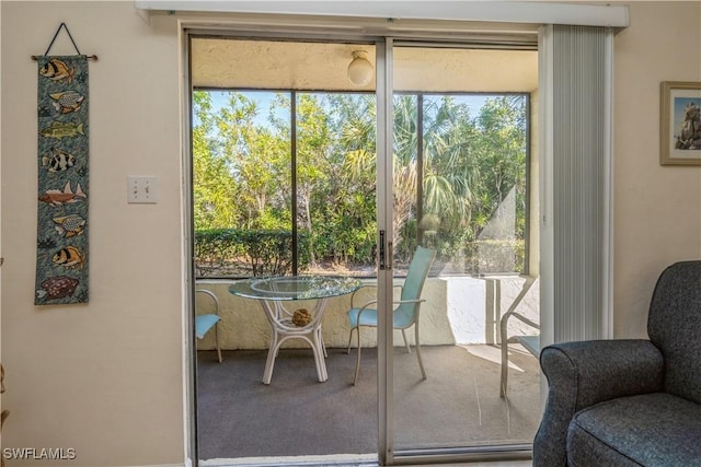 doorway to outside with a healthy amount of sunlight and carpet