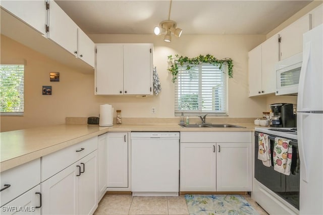 kitchen featuring light tile patterned flooring, white appliances, sink, and white cabinets