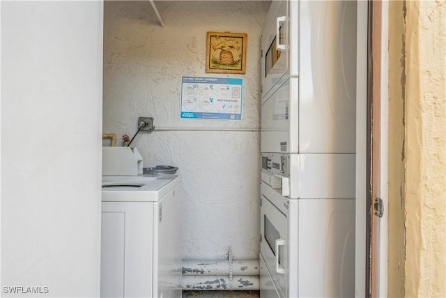 clothes washing area featuring stacked washer and dryer