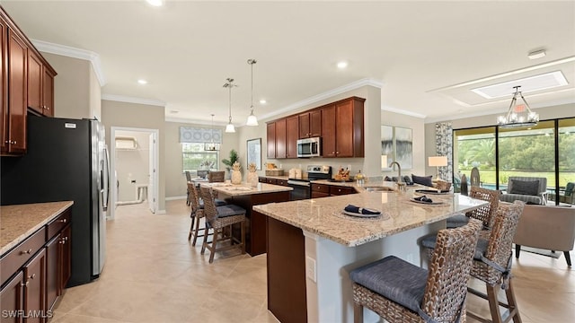 kitchen with sink, a breakfast bar area, hanging light fixtures, and stainless steel appliances