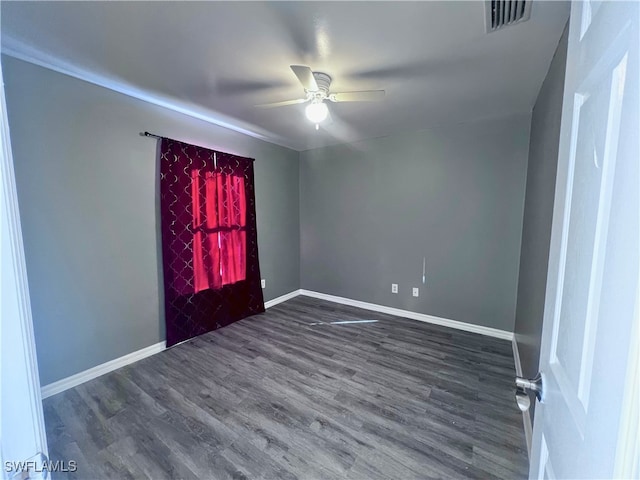 unfurnished room with visible vents, dark wood-style flooring, ceiling fan, and baseboards