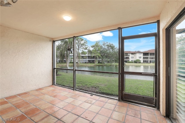 unfurnished sunroom featuring a water view and a wealth of natural light