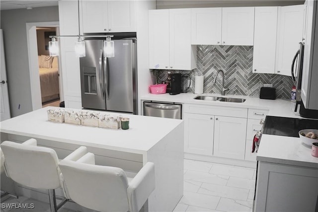 kitchen featuring white cabinetry, sink, backsplash, and stainless steel appliances