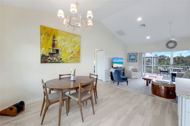 dining room with ceiling fan with notable chandelier, light hardwood / wood-style floors, and lofted ceiling