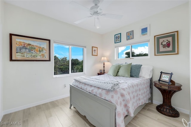 bedroom with ceiling fan, multiple windows, and light wood-type flooring