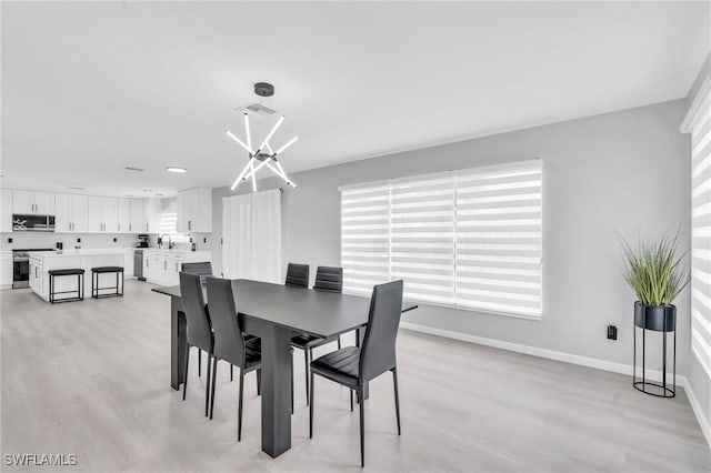 dining space featuring sink and light hardwood / wood-style floors