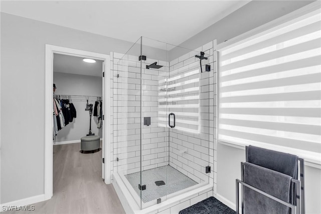 bathroom with hardwood / wood-style flooring and a shower with shower door