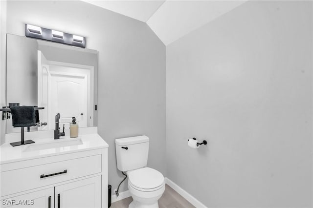 bathroom with vanity, wood-type flooring, vaulted ceiling, and toilet