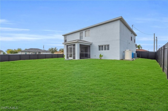 back of property with a sunroom, cooling unit, and a lawn