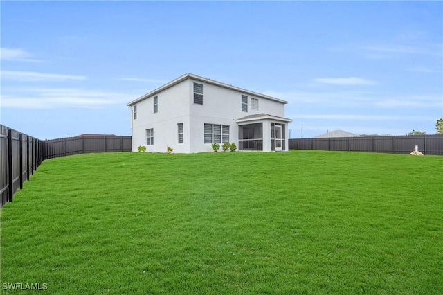 back of property with a yard and a sunroom