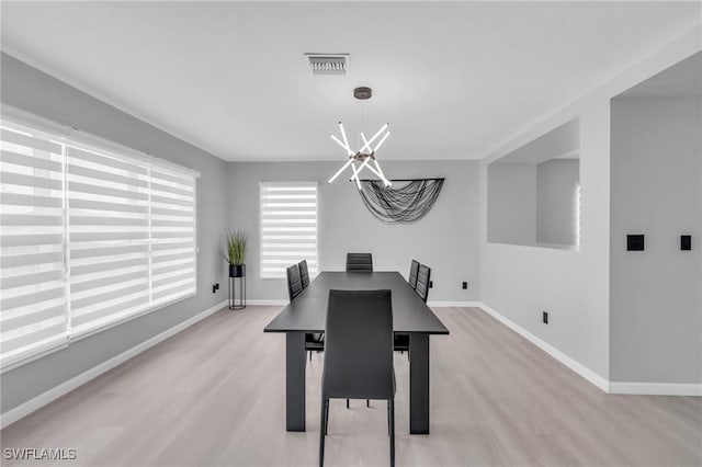 dining area with a notable chandelier and light wood-type flooring