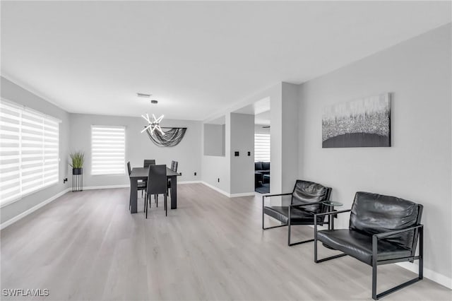 dining space with a notable chandelier and light hardwood / wood-style flooring