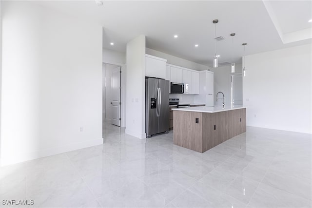 3005 28th St SW, Lehigh Acres, FL 33976 - kitchen with appliances with stainless steel finishes, an island with sink, light countertops, white cabinets, and decorative light fixtures
