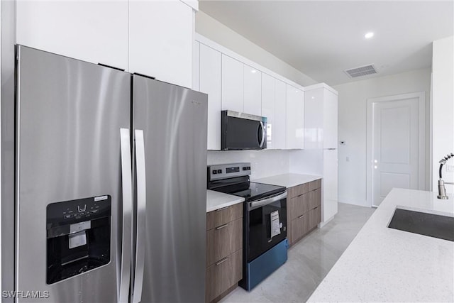 3005 28th St SW, Lehigh Acres, FL 33976 - kitchen featuring appliances with stainless steel finishes, modern cabinets, a sink, white cabinets, and recessed lighting