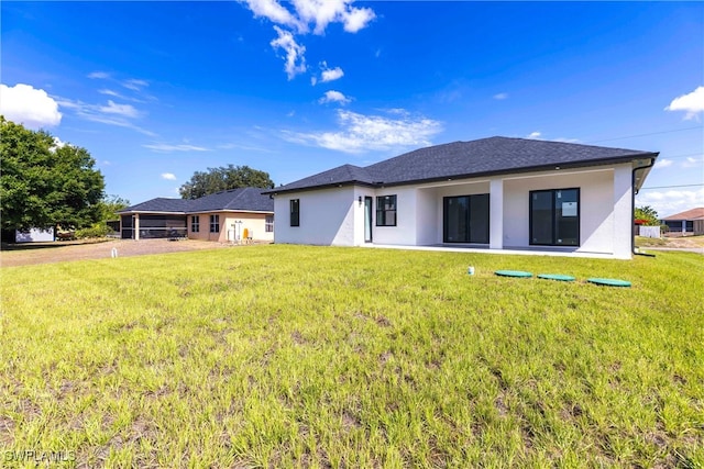 3005 28th St SW, Lehigh Acres, FL 33976 - rear view of property with stucco siding and a yard