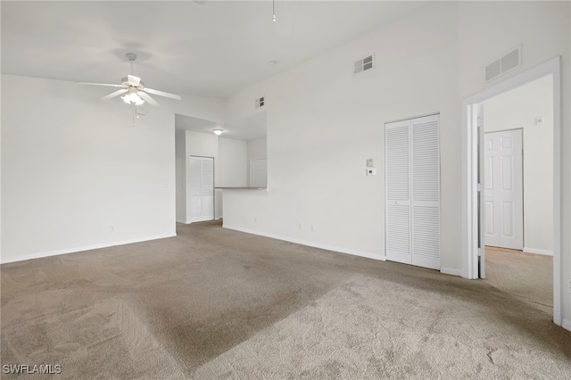 empty room featuring high vaulted ceiling, ceiling fan, and carpet flooring