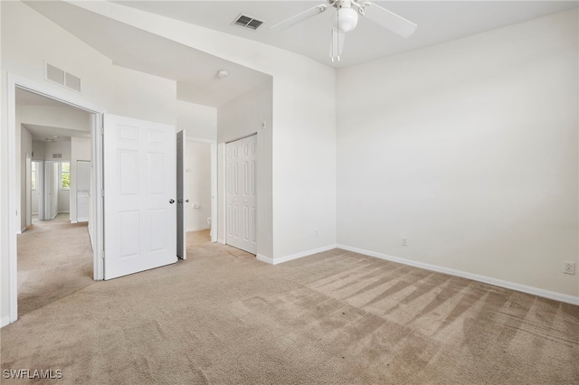 spare room with ceiling fan and light carpet