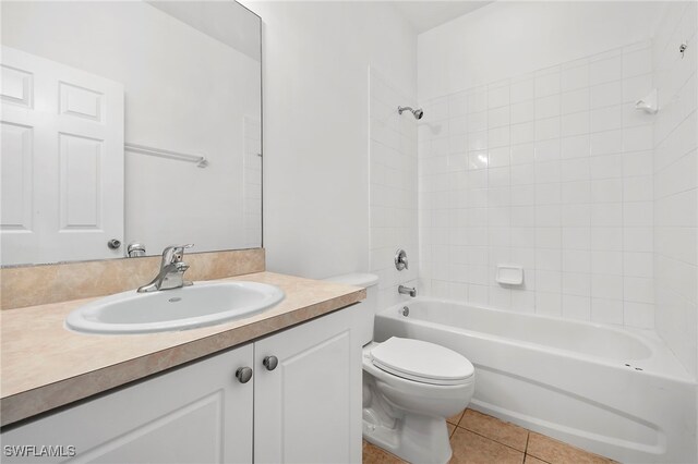 full bathroom featuring tiled shower / bath, tile patterned floors, toilet, and vanity