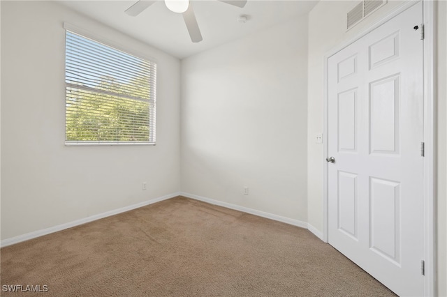 carpeted spare room with ceiling fan