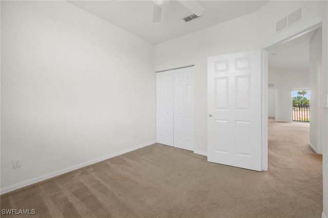 unfurnished bedroom featuring carpet floors, ceiling fan, and a closet