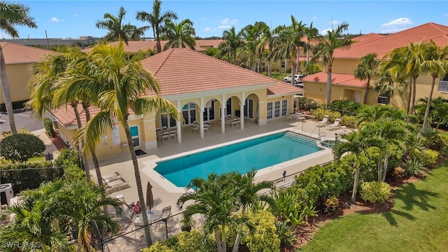 community pool with fence, a patio, and french doors