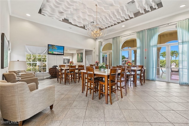 dining space with crown molding, french doors, and a towering ceiling