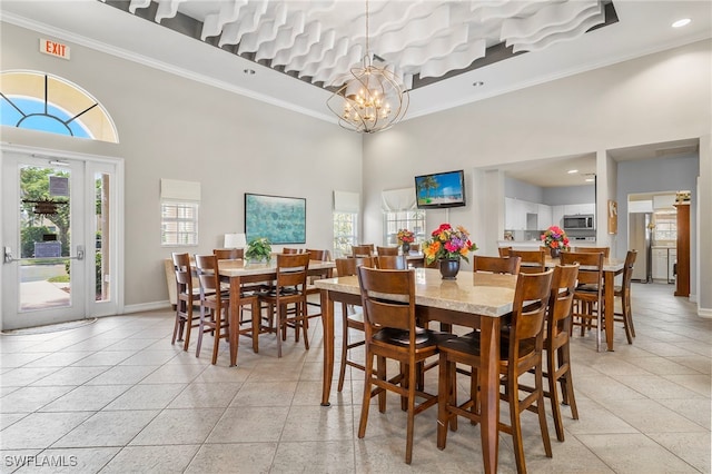 dining area featuring light tile patterned floors, ornamental molding, a chandelier, and a high ceiling