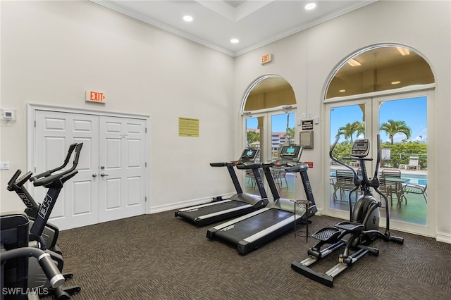 workout area with french doors, ornamental molding, dark carpet, and a high ceiling