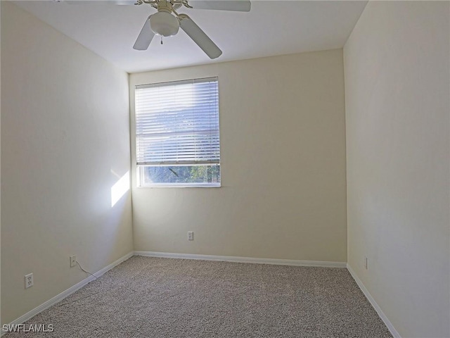 carpeted empty room featuring baseboards and ceiling fan
