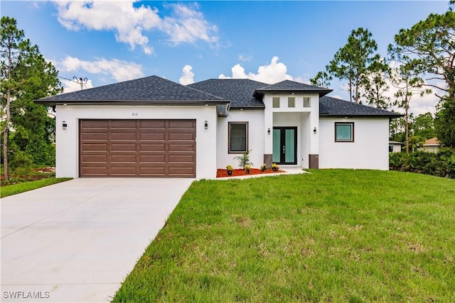 prairie-style home featuring stucco siding, a garage, concrete driveway, and a front lawn