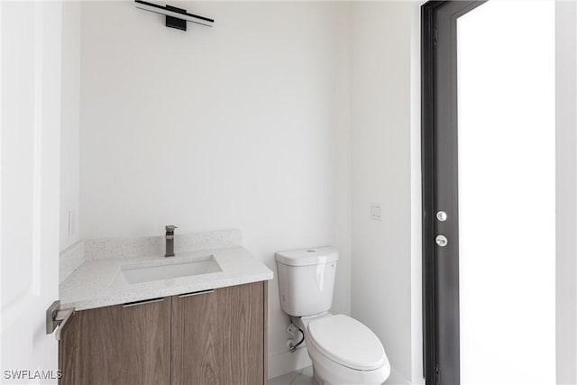 half bathroom featuring toilet and vanity
