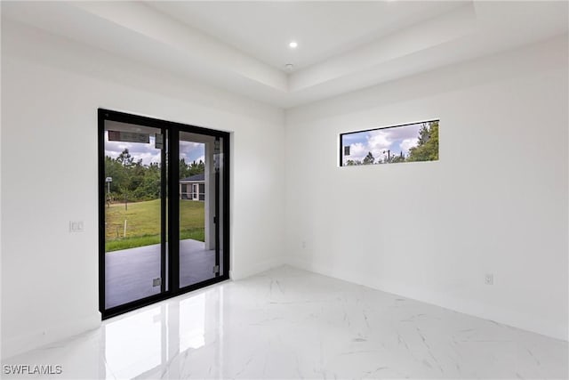 spare room featuring marble finish flooring, recessed lighting, and a raised ceiling