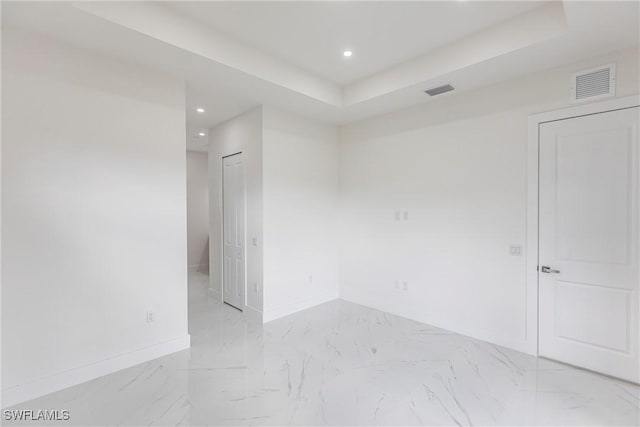 unfurnished room featuring baseboards, recessed lighting, light marble finish floors, and a raised ceiling