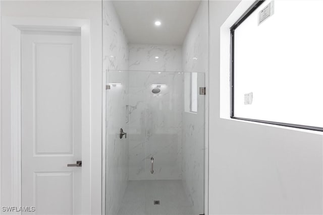 bathroom featuring a marble finish shower and recessed lighting