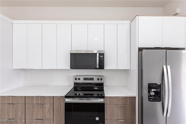 kitchen with appliances with stainless steel finishes, modern cabinets, and white cabinetry
