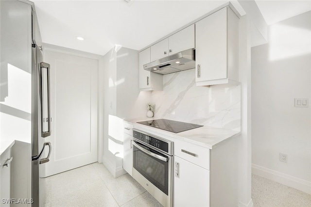 kitchen featuring light stone counters, white cabinetry, stainless steel appliances, and backsplash