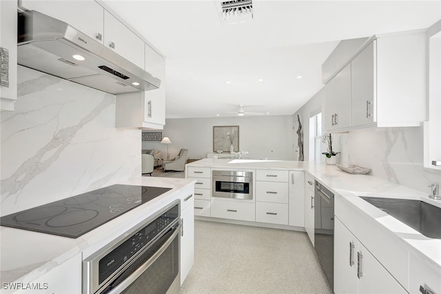 kitchen with sink, white cabinetry, backsplash, ventilation hood, and black appliances