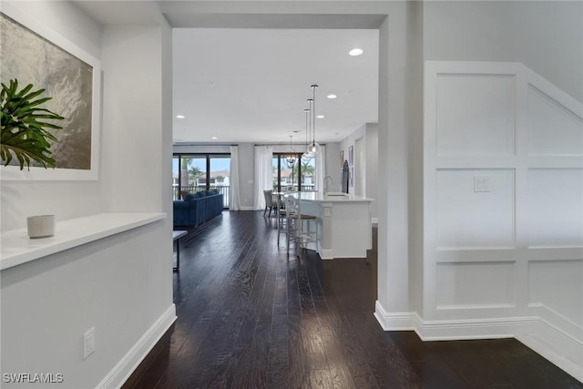 corridor featuring sink and dark hardwood / wood-style floors