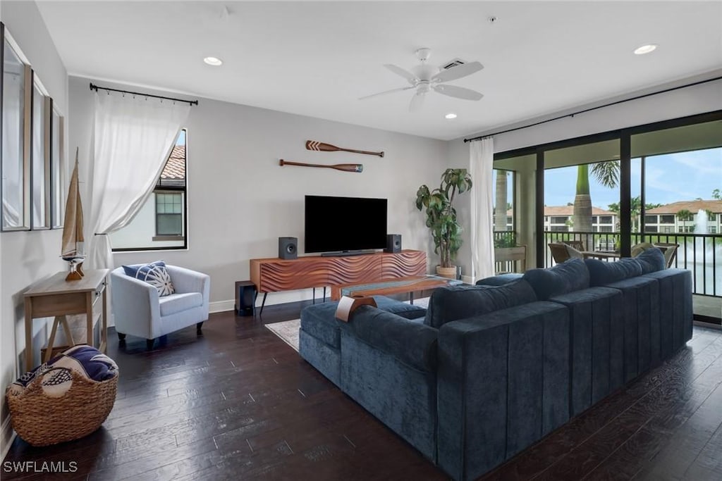 living room with dark wood-type flooring and ceiling fan