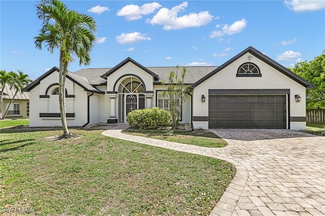 ranch-style home featuring a garage, a front lawn, decorative driveway, and stucco siding