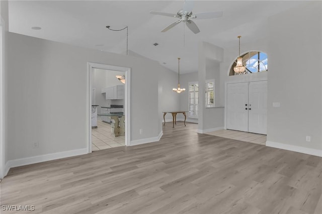 entrance foyer with baseboards, ceiling fan with notable chandelier, and light wood-style floors