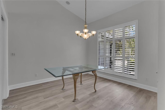 dining room with a notable chandelier, baseboards, vaulted ceiling, and wood finished floors