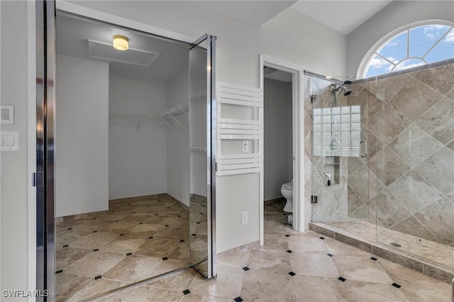 full bath featuring a shower stall, toilet, and a spacious closet